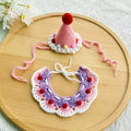 Pink and purple handmade crochet pet hat and collar set with colorful pom-poms, adjustable ties 