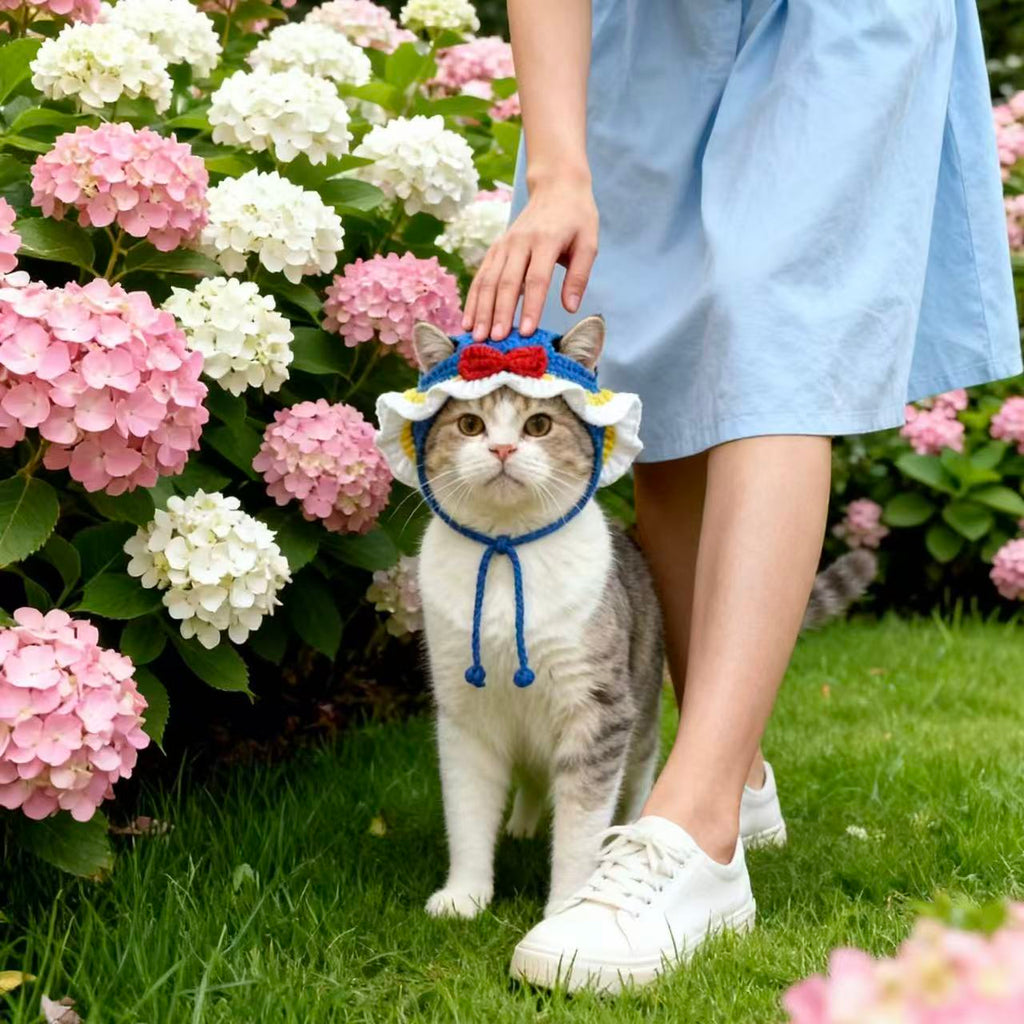 Cute Cat Wearing Handmade Crochet Pet Hat, Blue Knitted Headwear with Ruffled Edge, Standing in Pink Hydrangea Flowers, Stylish Pet Sun Hat for Outdoor Strolls